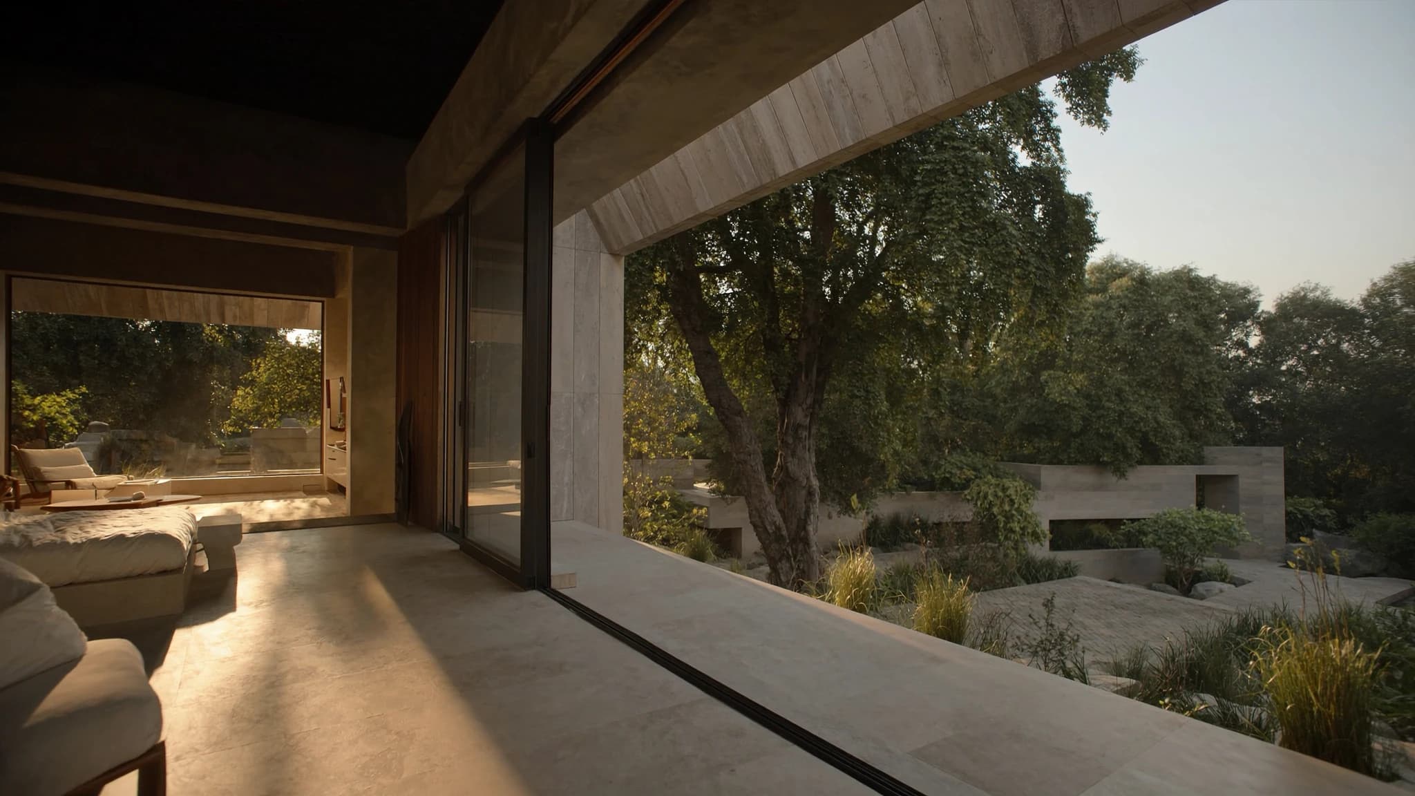 A bedroom opening through full-height glass onto a mature tree and stone terrace, morning light pooling across the travertine floor.
